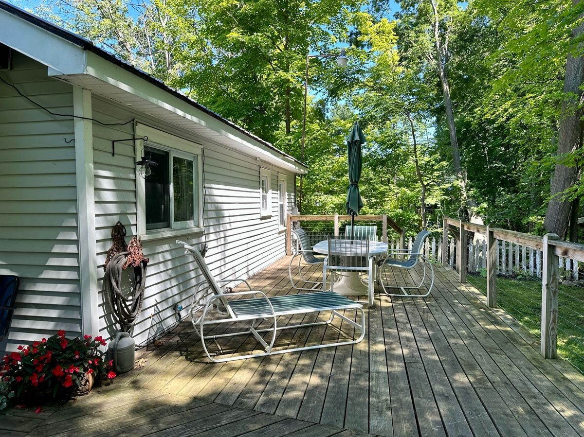 Deck lounging area with Adirondack chairs looking toward the river