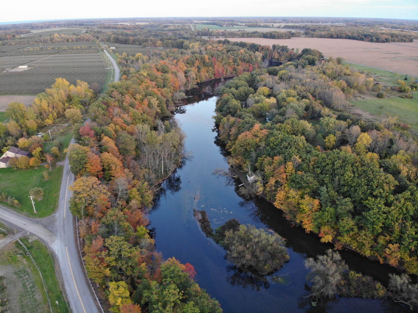 Aerial view of the Oak Orchard River winding through peak fall foliage