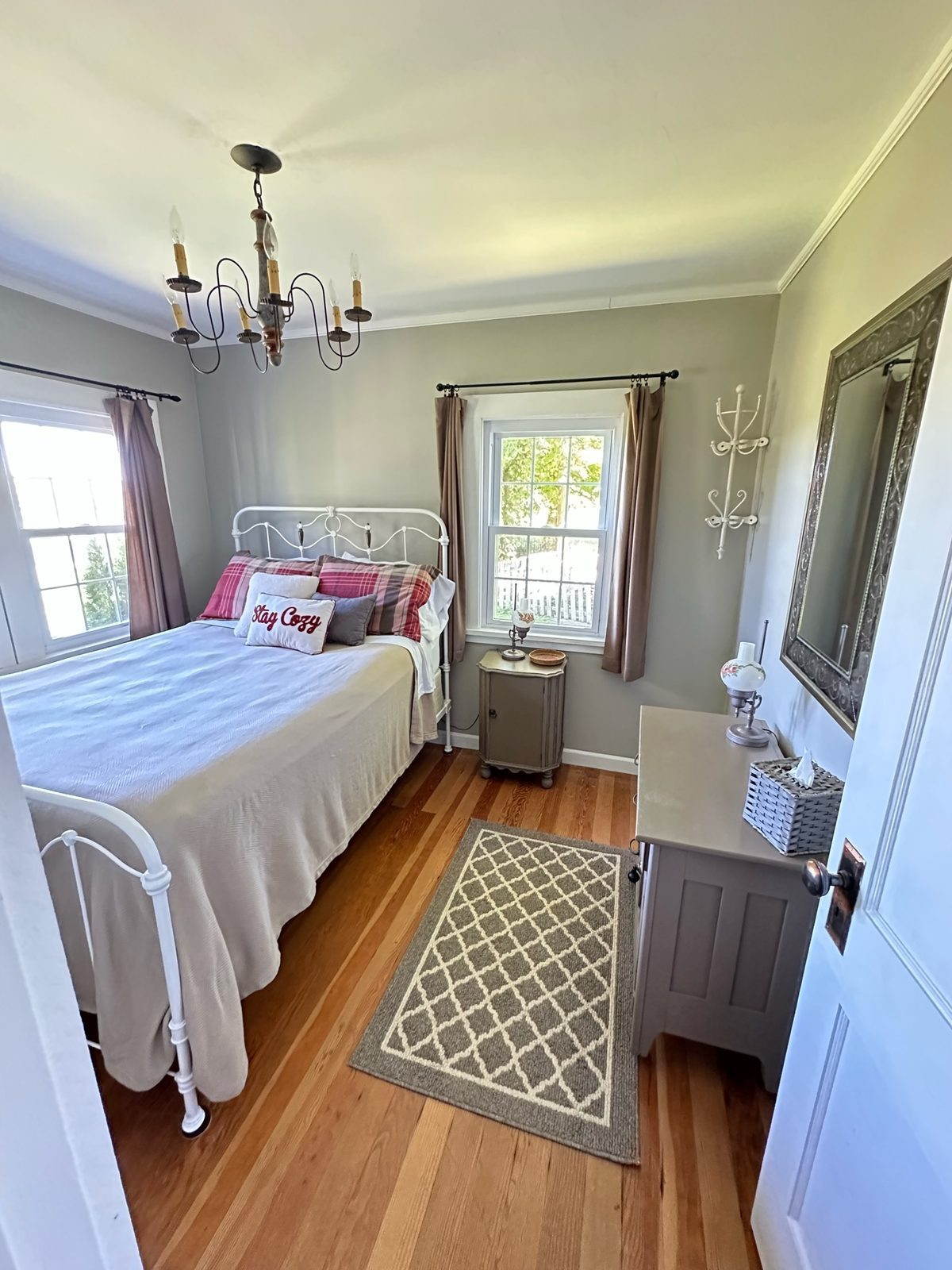 Primary bedroom with queen bed, iron frame, and chandelier